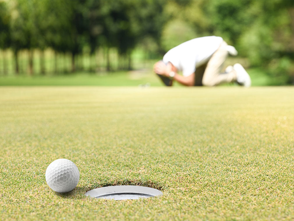 Golfer bent over missing a putt