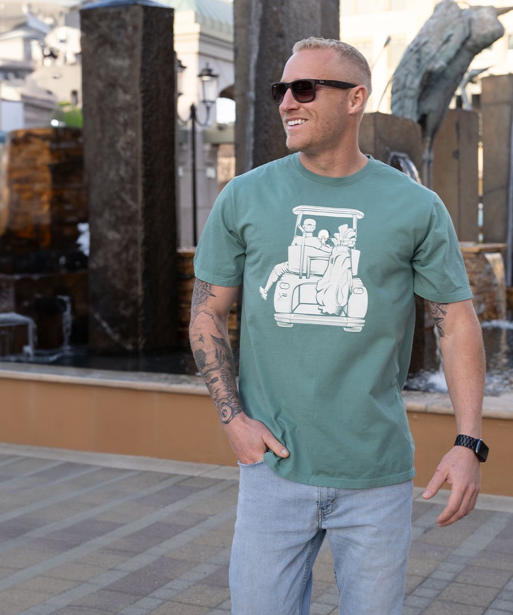 Man wearing sunglasses with his hand in his pocket looking off into the distance.